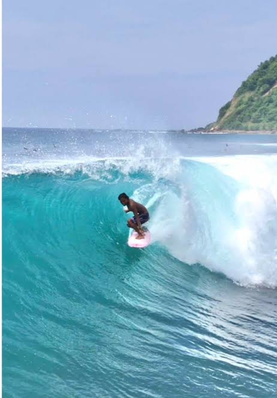 Surfer tucked inside a turquoise barrel in South Lombok